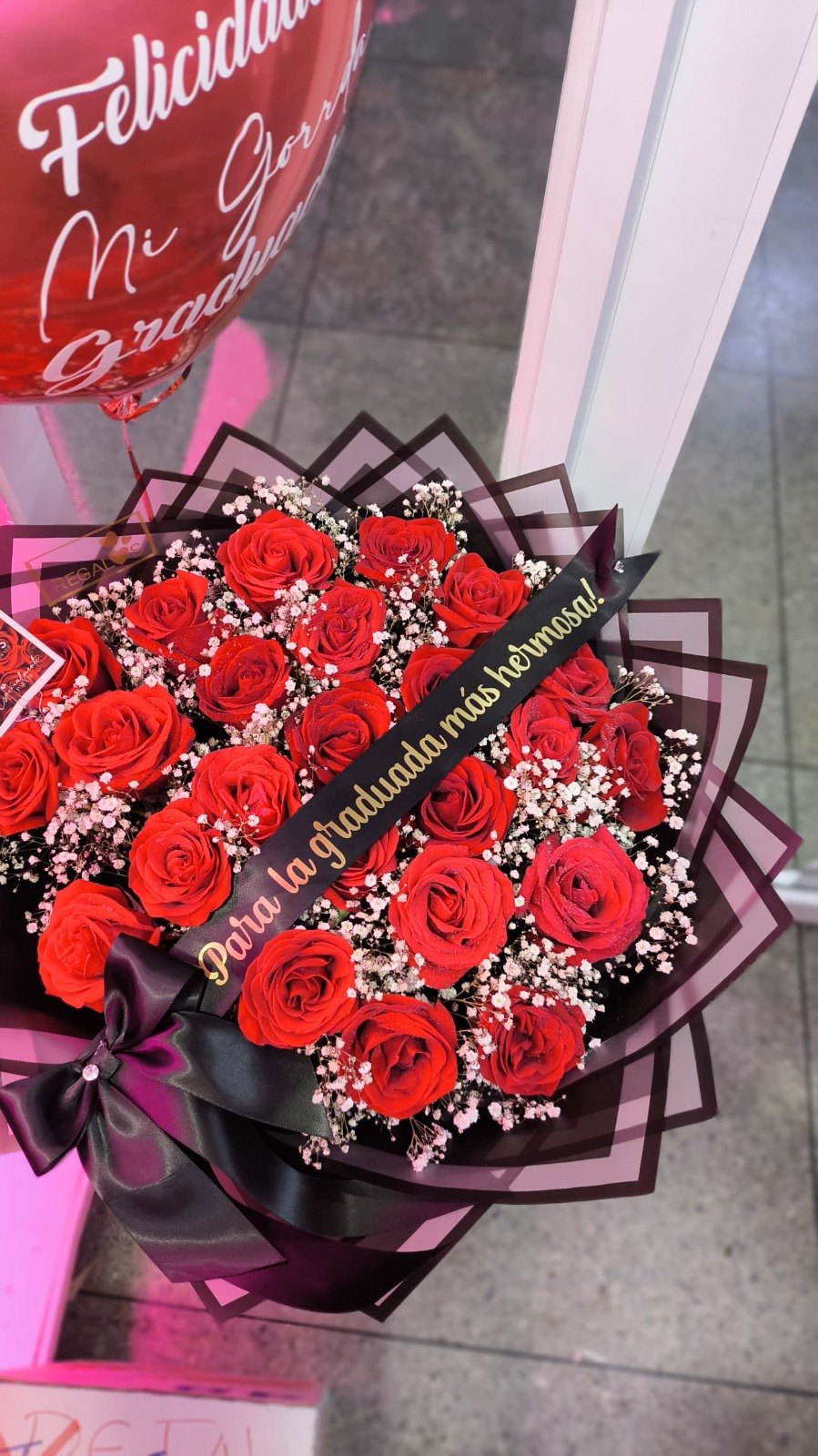 Ramo de rosas rojas con cinta para la graduada